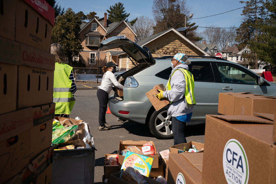 Volunteers load food packages into clients’ cars in Englewood, New Jersey.