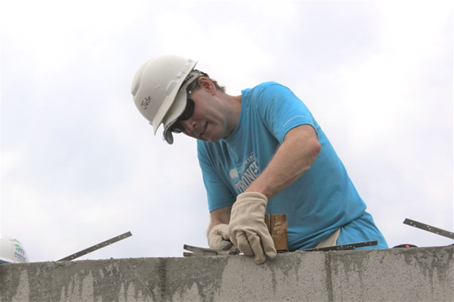 A Habitat Broward volunteer prepares truss straps to protect against hurricane-force winds.